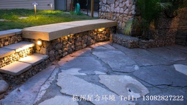 绿化工程把石笼墙表面弄平整，盖上石板做成板凳。